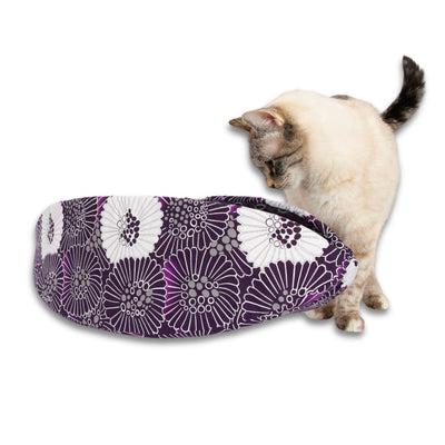 The Cat Canoe® taco-shaped modern cat bed is made here in a black, white, and purple floral print and lined with a coordinating geometric. The cat model weighs about 7 pounds, and our modern pet bed fits animals to about 18 pounds.