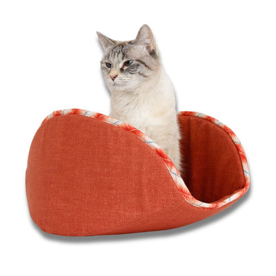 A small six-pound cat models our jumbo-size CAT CANOE, made for big cats who weigh 18 pounds or more. This bed was made in an orange terra-cotta color fabric and is trimmed with a bias-cut ikat print. Cotton fabrics over foam, made in the USA.