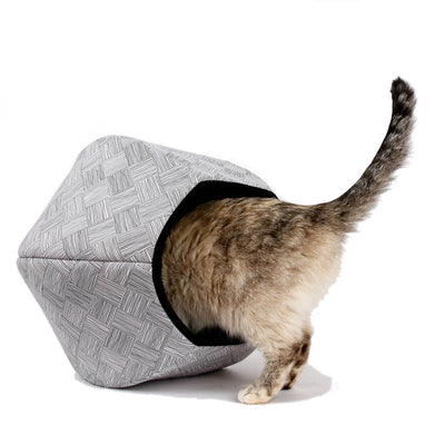 A small cat going head first into the Cat Ball® cat bed made with a black and white grid print. 