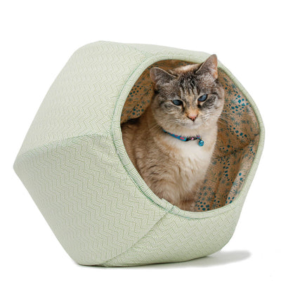 This Cat Ball® cat bed is made with a green geometric print that looks like Japanese washi paper for origami. The floral lining suggests cherry blossoms.