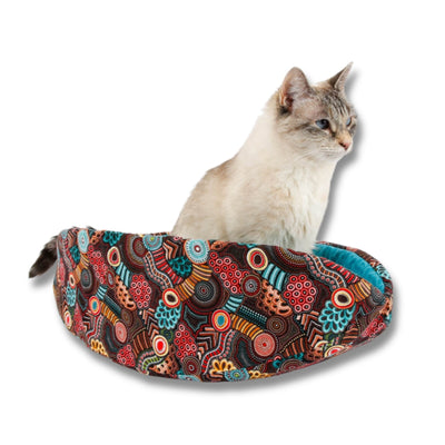 The Cat Canoe modern cat bed is made with a bold print that references Aboriginal Australian design and patterns. Our innovative taco-shaped cat bed design is long and narrow with high sides and the foam-filled panels allow fat cats to get in.