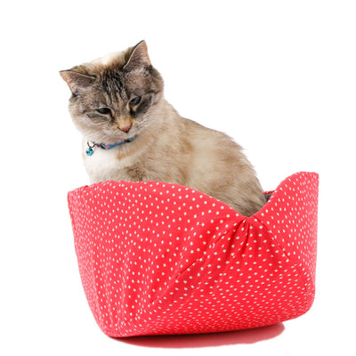 A small cat sits inside a Cat Canoe® modern cat bed. This pet bed is long and narrow with high sides that tend to form closely around your sleeping pet, helping to retain body heat.