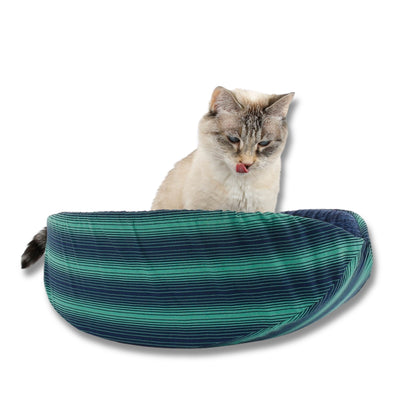 The Cat Canoe modern cat bed is made here in a bold green and blue stripe and lined with blue cotton with a textured look. The model is a small 7 pound cat, but this bed fits pets to about  18 pounds. 