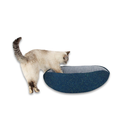 A small cat explores a Cat Canoe®
made with a teal fabric with a paint splatter look. Our modern cat nest is made in the USA and ready to ship. 


