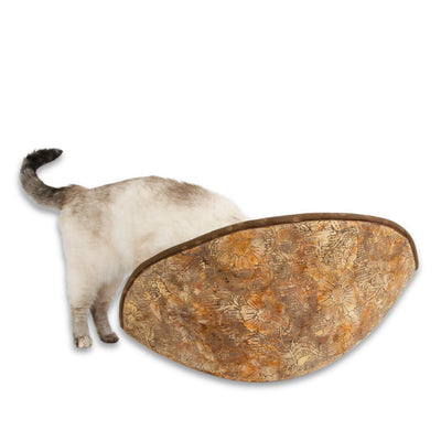 A small cat explores the jumbo-size  Cat Canoe® cat bed made with a brown floral batik and other cotton fabric over foam panels. 