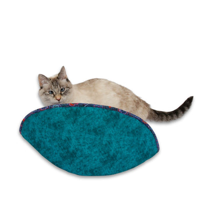 Our jumbo-size Cat Canoe® will accommodate multiple cats or one big one. We make these beds with cotton fabrics over flexible foam panels. This bed combines a bold teal with a moody purple lining, which will help to disguise fur shedded by cats with dark or tabby coats. Our beds are made in the USA and ready to ship.