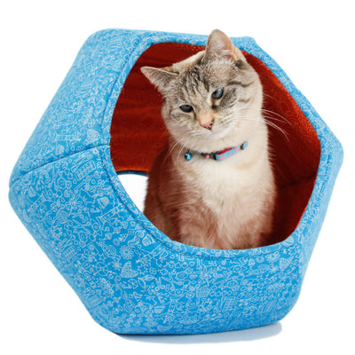 The Cat Ball® cat bed is a modern cat bed design, a cave-like pet bed with two openings because all cats want two doors to choose from. This bed is made with complimentary blue and orange fabrics printed with line drawings of flowers and fanciful objects.