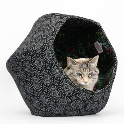 This Cat Ball® cat bed is made with a black circular sunburst pattern on a black background, and lined with a multi-color circular print. 
